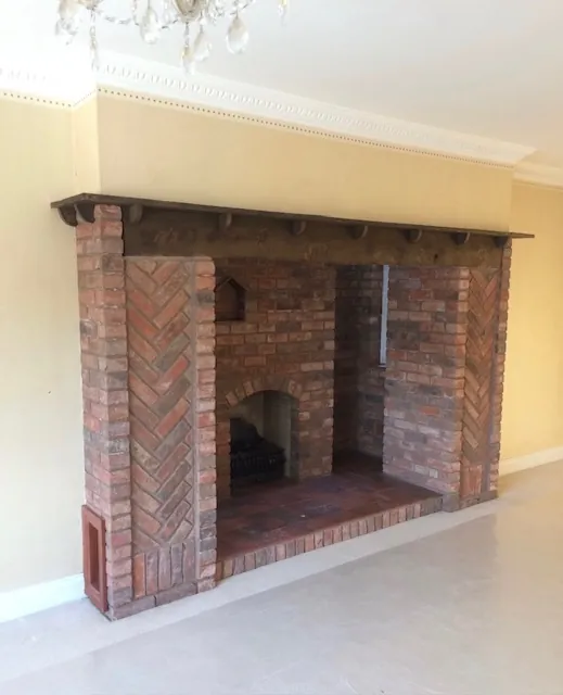 The original handmade-style brick fireplace with herringbone detailing, before the transformation