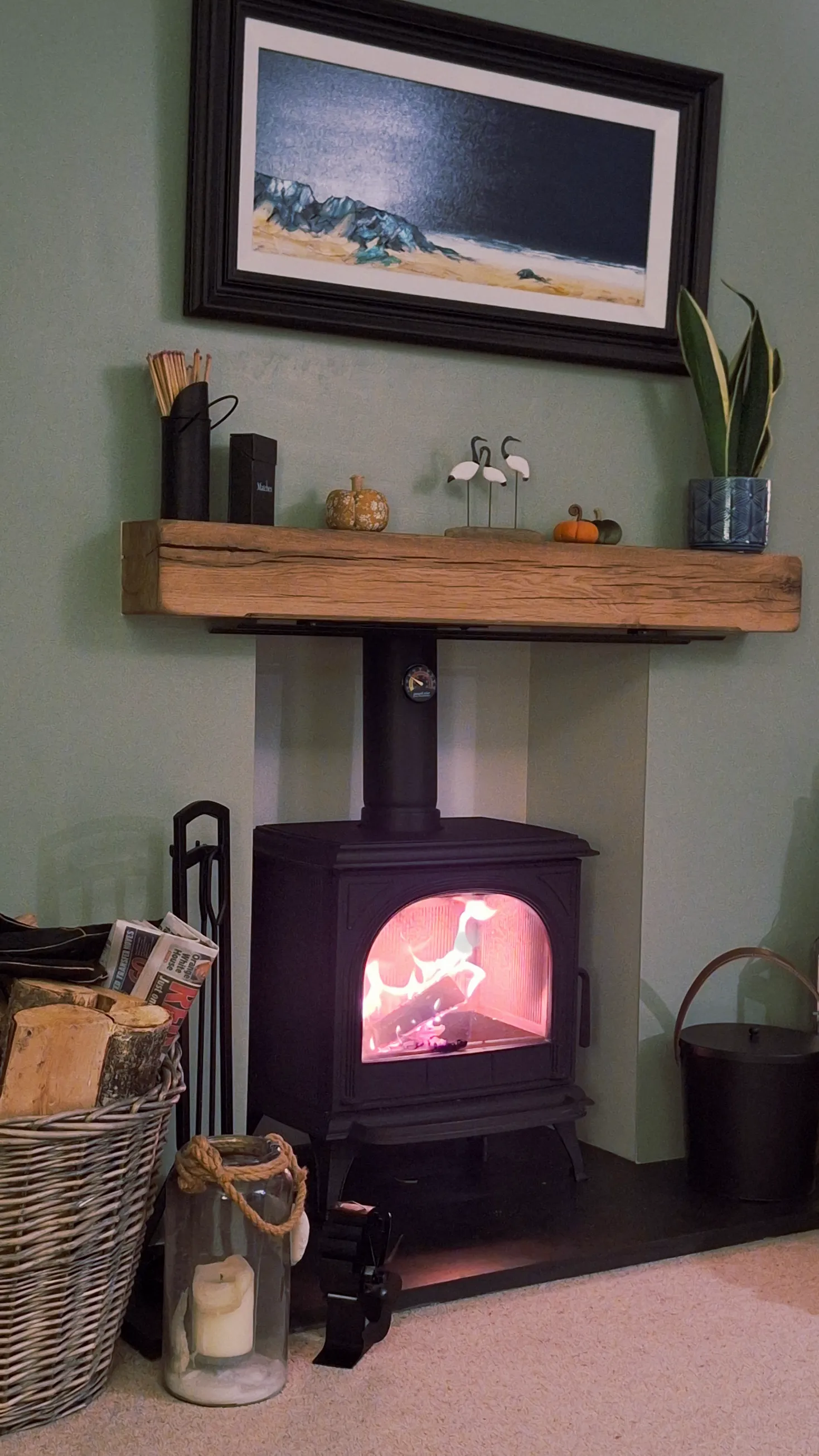 The wood burning stove lit, with a solid oak beam mantel above