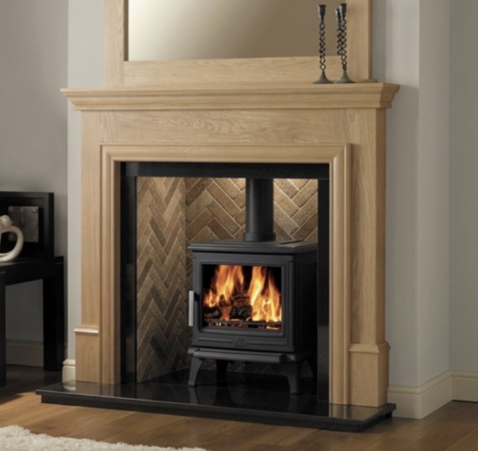 A solid oak timber fireplace surround fitted around a wood burning stove in a Yorkshire home